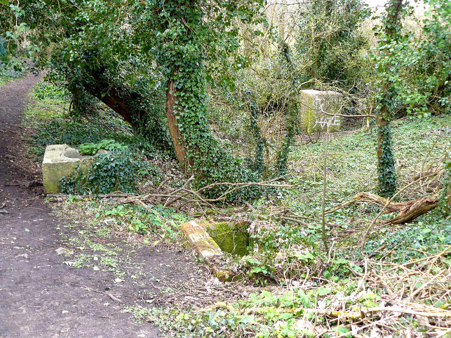 Brick and concrete shafts on material tipped to strengthen the railway embankment.